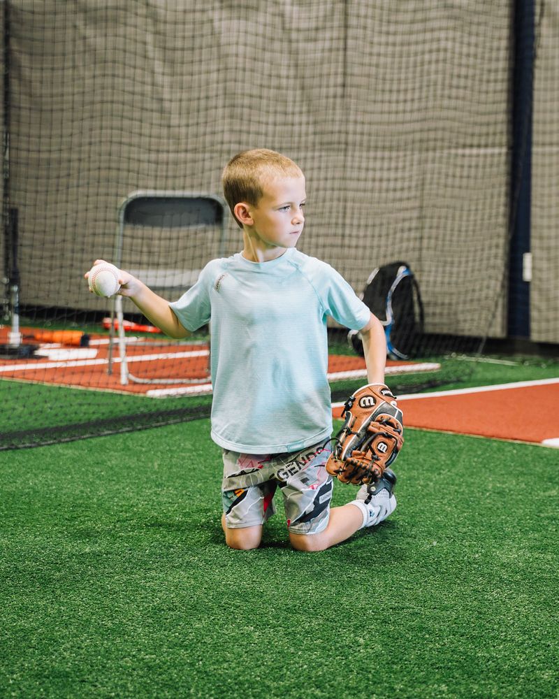 Young player kneeling to throw during a Compete BP group class