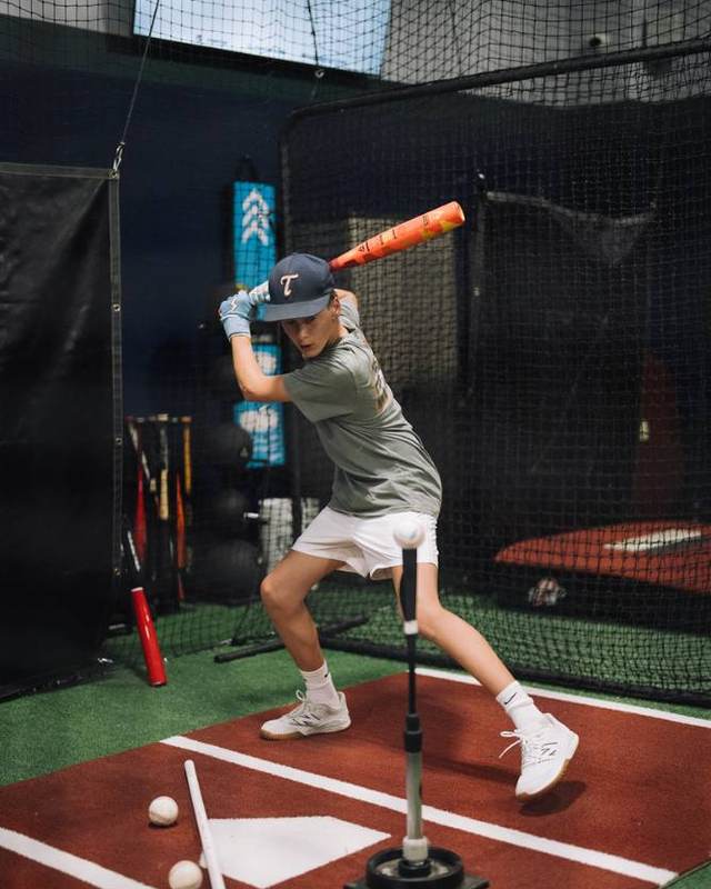 Youth hitter working off a tee in a Compete BP cage